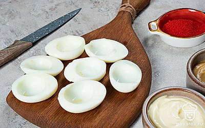 Сварите яйца. В миску положите яйца и залейте их водой. Поставьте на плиту и варите 10 минут после закипания. Остудите в холодной воде и очистите от скорлупы. Разрежьте каждое яйцо пополам и уберите желтки.