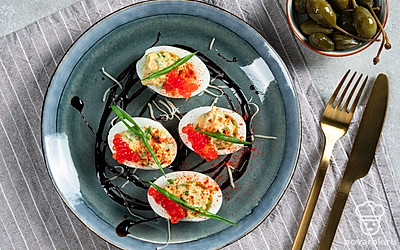 На каждую половинку белков положите крупный кусочек пера зеленого лука.