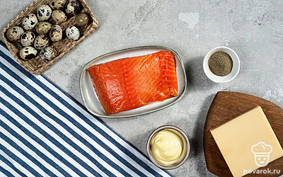 Перепелиные яйца обработайте 3%-ным раствором соды, промойте, сварите вкрутую, остудите и затем почистите. С лосося срежьте кожу. Помидоры черри и листья салата помойте и просушите. С маслин слейте рассол. Затем каждый помидор черри и маслину порежьте на три кружка.