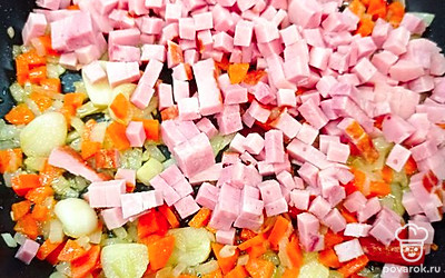 Добавить на сковороду нарезанные кубиками лук и морковь, обжарить, добавить ветчину и карбонад.