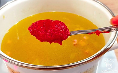 Переложить поджарку в готовый бульон, добавить порезанный кубиками картофель и три чайные ложки томатной пасты.