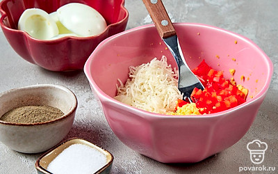 Приготовьте фаршированные яйца. Соедините желтки с чесноком, сыром и перцем. Посолите, поперчите, заправьте майонезом и хорошенько перемешайте. Получившейся начинкой нафаршируйте яйца.