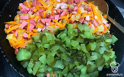 Соленые огурчики нарежьте мелкими кубиками и выложите в сковороду к другим продуктам. Жарьте 7 минут.