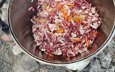 В закипающую в чане воду добавляем все нарезанные продукты, варим 50 минут. В процессе добавляем соль, специи, огурцы, лимон. 