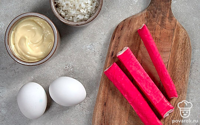 Яйца сварите вкрутую, остудите в холодной воде, почистите. Рис отварите. Крабовые палочки извлеките из индивидуальной упаковки. Листья салата для подачи вымойте, обсушите на бумажных полотенцах.