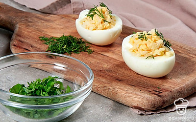 Приготовьте блюдо. Соедините желтки с рисом и укропом. Посолите, поперчите, заправьте сметаной и хорошо перемешайте. Получившейся начинкой аккуратно нафаршируйте яйца.