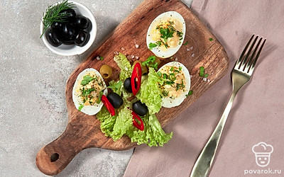 Посыпьте фаршированные яйца мелко рубленной кинзой.