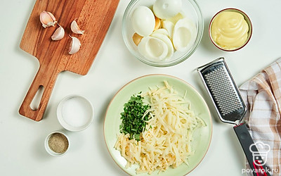 Займитесь начинкой. Сыр измельчите при помощи терки, размер ячеек выбирайте в соответствии с собственными вкусовыми предпочтениями. Кинзу измельчите. Чеснок пропустите через пресс или мелко нарежьте.