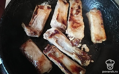 Ребра обжарить на сковороде на сильном огне с двух сторон до румяности и добавить к гороху.