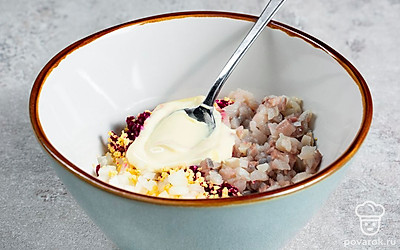 Приготовьте блюдо. Разрежьте селедку на две части: первую часть порежьте на дольки, а вторую — на мелкие кубики. Мелко натрите свеклу и отожмите от лишнего сока. Разомните желтки. Соедините желтки со свеклой, селедкой и луком, заправьте майонезом и хорошо перемешайте. Нафаршируйте яйца начинкой и выложите сверху по дольке селедки.