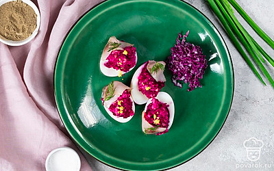 Украсьте фаршированные яйца под шубой измельченным зеленым луком.