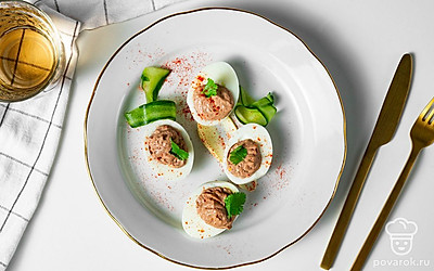 Готовое блюдо уложите на тарелку, сверху каждое яйцо украсьте пером зеленого лука и листиком петрушки.