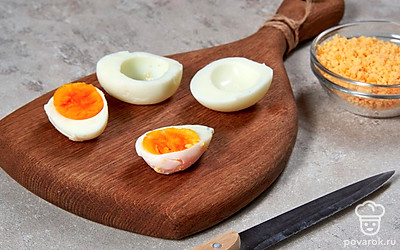 Подготовьте яйца. Отваренные яйца очистите от скорлупы и разрежьте пополам. Желтки извлеките и переложите в отдельную емкость. Половинки белков разложите на блюде с плоским дном.