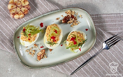 Остатком сыра посыпьте каждую половинку, сверху украсьте веточкой петрушки и ломтиком свежего огурца по желанию. Готовую закуску подавайте к столу.