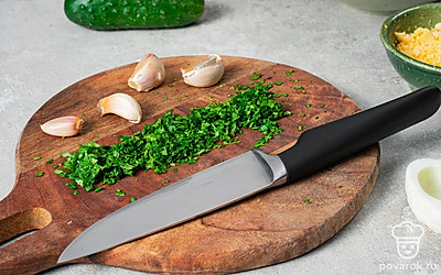 Приготовьте начинку. Очищенные яйца разрежьте на две части, желтки извлеките, натрите их на средней или крупной терке. То же самое повторите с зубчиками чеснока. Брынзу разомните вилкой. Петрушку мелко порубите. Подготовленные ингредиенты переложите в глубокую миску и тщательно перемешайте.