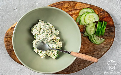 Приготовьте блюдо. Яичные белки аккуратно промойте и просушите, чтобы они стали более чистыми. Далее нафаршируйте яйца готовой начинкой. Огурец нарежьте круглыми ломтиками. После этого аккуратно вставьте овощные дольки в готовое блюдо.