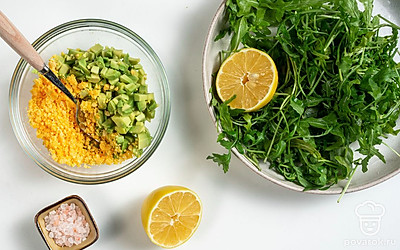 Приготовьте начинку. Подготовленные яйца разрежьте на две части. Желтки извлеките и переложите их в чашу блендера. Авокадо нарежьте небольшими кубиками и добавьте к желткам. Затем выложите к ингредиентам зелень, влейте лимонный сок и добавьте соль по вкусу. Измельчите содержимое чаши до однородной пасты, после чего переложите ее в кулинарный мешок.