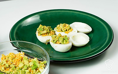 Приготовьте закуску. Оставшиеся яичные белки нафаршируйте начинкой из авокадо, желтков и зелени. Готовое блюдо посыпьте небольшим количеством молотой паприки.