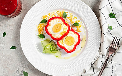 Подайте перцы, фаршированные сыром и яйцом, на тарелке с листовым салатом.