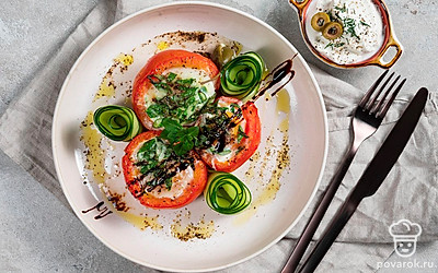 Фаршированные помидоры выложите из формы на блюдо для подачи, застеленное листьями салата. Украсьте помидоры розочками из огурца сверху, либо положите их рядом с помидорами на блюдо.