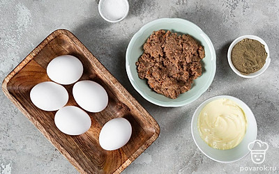 Яйца вымойте. В небольшую кастрюлю налейте воду, положите в нее яйца и доведите воду до кипения. После этого варите яйца еще 7 минут, затем остудите их под холодной водой. Откройте упаковку с печеночным паштетом. Зеленый лук помойте и мелко нарежьте.