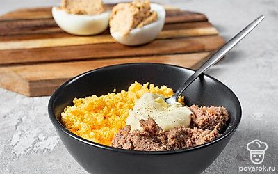 Сделайте начинку. К желткам добавьте печеночный паштет и майонез. Посолите и поперчите ингредиенты по вкусу. Затем при помощи вилки смешайте компоненты до однородной массы. Нафаршируйте начинкой подготовленные половинки белков.