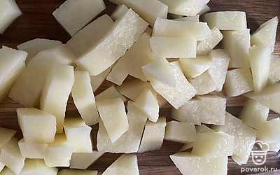 Картофель нарежьте кубиком и поместите в бульон.