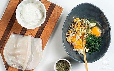 Начните приготовление. Очищенные яйца нарежьте небольшими по размеру кубиками, а зелень измельчите, отложив несколько веточек петрушки для подачи. В глубокую миску выложите измельченные ингредиенты, одно сырое яйцо, соль и травы по вкусу. Содержимое миски тщательно перемешайте.