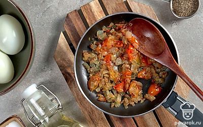 Начните приготовление. Лук и помидоры нарежьте небольшими кубиками. Далее влейте в сковороду растительное масло и поставьте ее на огонь разогреваться. Когда масло раскалится, выложите лук и обжарьте до появления золотистого цвета. Добавьте помидоры и протушите до испарения жидкости.