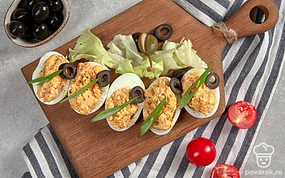 Готовую закуску подавайте к столу охлажденной. А чтобы сделать блюдо еще интереснее, воспользуйтесь листьями салата. Зелень выложите на тарелку для подачи, а сверху разложите фаршированные яйца.