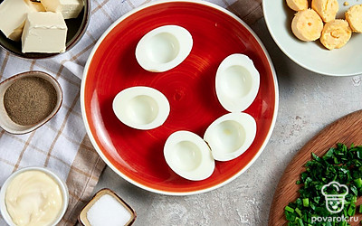 Подготовьте яйца. Яйца очистите от скорлупы и разрежьте пополам. Желтки достаньте и переложите в отдельную миску. Половинки белков разложите на блюде.