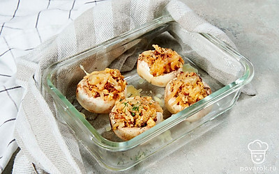 Приготовьте фаршированные шампиньоны. Включите духовку на 200 градусов. В шляпки шампиньонов выложите начинку и поставьте запекаться в духовку на 30 минут.