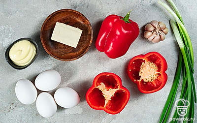 Куриные яйца тщательно промойте, сварите вкрутую, остудите и очистите от скорлупы. Плавленый сыр поместите в морозильную камеру на 5-10 минут. На момент приготовления блюда он должен быть твердым. Болгарские перцы тщательно промойте, просушите, после чего удалите плодоножку и семена, оставляя только стенки. Зубчики чеснока очистите от шелухи, сполосните. Зелень хорошо вымойте, просушите.