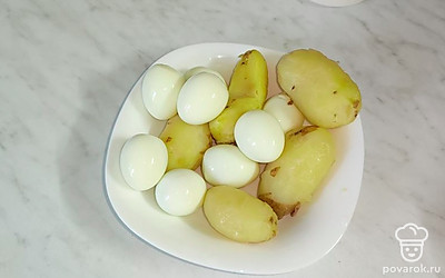 Отварите картофель в мундире и яйца. Остудите и очистите.