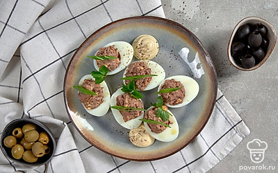 Перед подачей украсьте яйца, фаршированные куриной печенью, зеленью и майонезом.