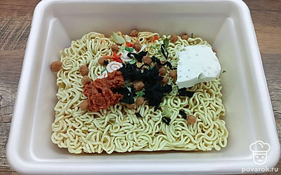 Пока жарятся грибы, займитесь лапшой. Выложите на сухую лапшу творожный сыр, пасту Том Ям и водоросли вакаме.