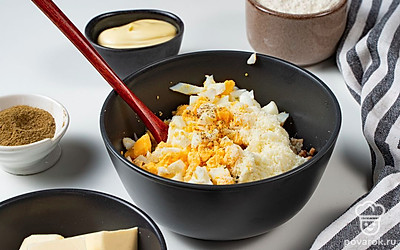 Приготовьте начинку. На сковороду выложите сливочное масло, поставьте ее на огонь разогреваться. Когда масло растопится, выложите на сковороду грибы, обжаривайте их до полуготовности около 5 минут. После этого снимите сковороду с огня и оставьте ее содержимое остывать. К грибам выложите яйца и тертый сыр. Посолите и поперчите начинку по вкусу, после чего тщательно перемешайте.