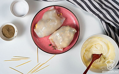 Подготовьте кальмаров. Аккуратно нафаршируйте тушки кальмаров приготовленной начинкой. Используя шпажки или зубочистки, закрепите отверстия морепродукта, чтобы при запекании его содержимое не вывалилось. После этого поместите кальмаров на противень или в глубокую форму. В отдельную миску выложите сметану, майонез и муку. Приправьте все солью и перцем, после чего перемешайте. Залейте кальмаров готовым соусом.