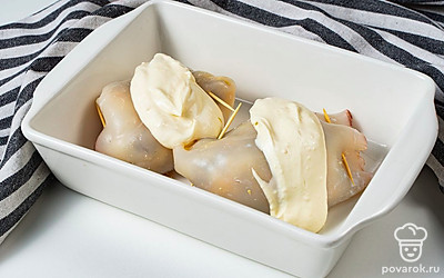 Приготовьте блюдо. Духовку включите разогреваться до 190 градусов. Когда она нагреется, поставьте блюдо запекаться на 30 минут. Готовых кальмаров слегка остудите, после чего извлеките из них шпажки.