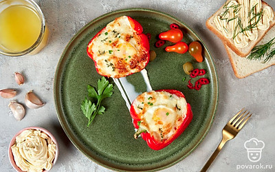 Подавайте болгарский перец, фаршированный яйцом и сыром, украсив порцию листиками петрушки.