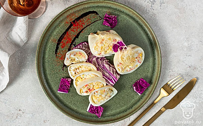 Сразу после приготовления посыпьте фаршированные кальмары сыром и подавайте.