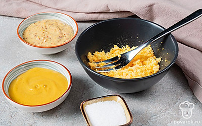 Займитесь яйцами. Залейте яйца холодной водой, включите сильный огонь. Дождитесь, когда вода закипит. После этого огонь убавьте до среднего, варите 10 минут. Остудите и почистите. Разрежьте яйца на две части. Извлеките желтки. В отдельной тарелке разомните их вилкой.