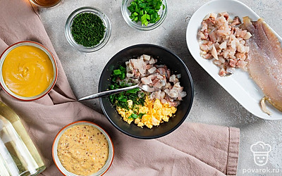 Приготовьте яйца, фаршированные сельдью. В тарелку к желткам добавьте лук, укроп, сельдь. Посолите, выложите горчицу двух видов, влейте растительное масло и уксус. Перемешайте. Разложите начинку в половинки белков.