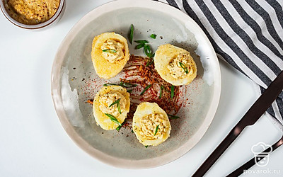 Готовую закуску подавайте к столу в горячем или холодном виде. В качестве украшения используйте зелень и приправу. Лук порубите мелкими кольцами и посыпьте ими блюдо. В конце слегка приправьте закуску молотой паприкой.