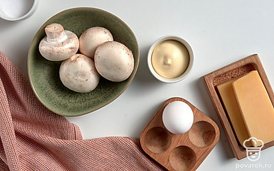 Шампиньоны хорошо помойте. Куриное яйцо помойте, сварите вкрутую и почистите. Листья салата помойте и обсушите. Разогрейте духовку до 180 градусов. Застелите противень пергаментом.