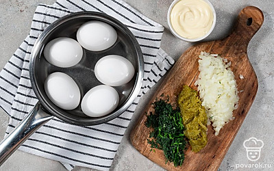 Отварите яйца. Положите яйца в кастрюлю и налейте воды. Поставьте на сильный огонь, дождитесь закипания и варите яйца 10 минут. После залейте холодной водой и очистите от скорлупы. Разрежьте яйца пополам и удалите желтки.