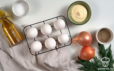 Яйца сварите вкрутую, остудите и очистите. Разрежьте их пополам, достаньте желтки. Лук почистите, вымойте и нарежьте мелкими кубиками. Укроп вымойте, обсушите и порубите. Маслины для подачи нарежьте колечками.