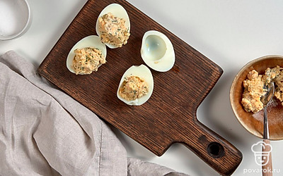 Нафаршируйте яйца. Возьмите чайную ложку и наполните белки начинкой, сверху сделайте "шапочку".