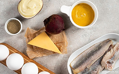 Куриные яйца обработайте 3%-ным раствором соды, промойте, сварите в течение 8 минут, остудите и почистите. Одно вареное яйцо для подачи разделите на желток и белок. Желток измельчите. Свеклу помойте, сварите в мундире до мягкости и очистите. Сельдь разделайте на филе без кожи и костей.