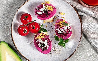 Посыпьте яйца, фаршированные свеклой, измельченным свежим луком и подавайте к столу.